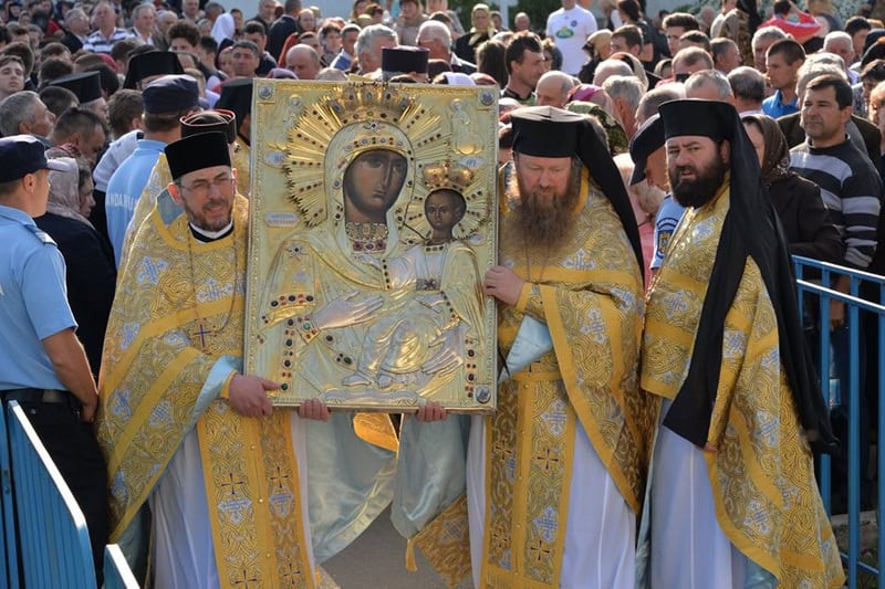 Preoți ortodocși purtând icoane făcătoare de minuni din Munții Neamțului.