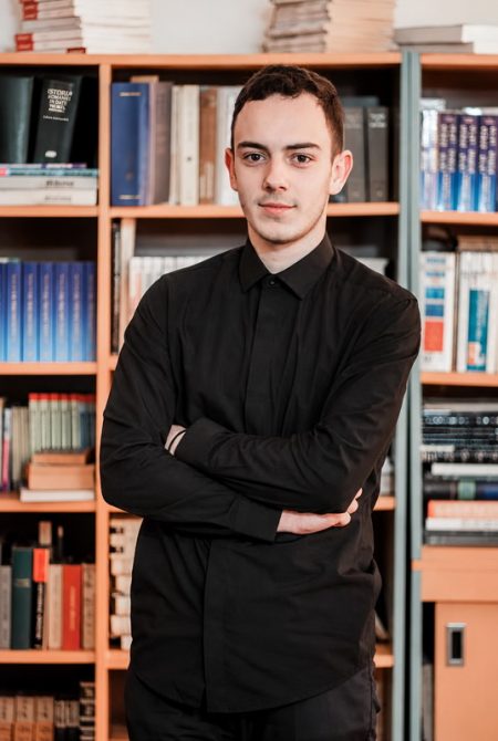 Radu Andrei Caia, elev la Liceul Carol I Bicaz, în fața bibliotecii.