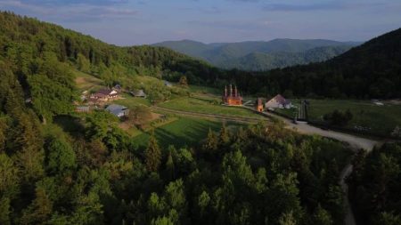 Peisaj montan cu sate și pădure în Neamț, România.