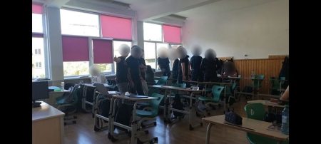 Elevi în uniformă neagră în sala de clasă, participând la protest.