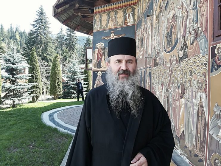 O zi specială la Mănăstirea Petru Vodă: starețul Hariton a împlinit 57 de ani. „Obștea unei mănăstiri poate fi gândită ca o familie unită” 1 Starețul Hariton la Mănăstirea Petru Vodă, înconjurat de picturi religioase și natură.