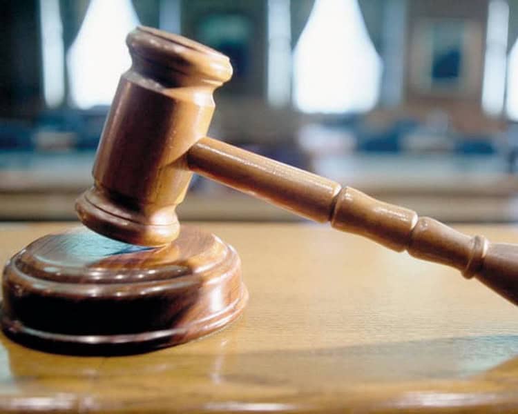 Ciocan de judecată pe o masă de lemn, simbol al justiției.