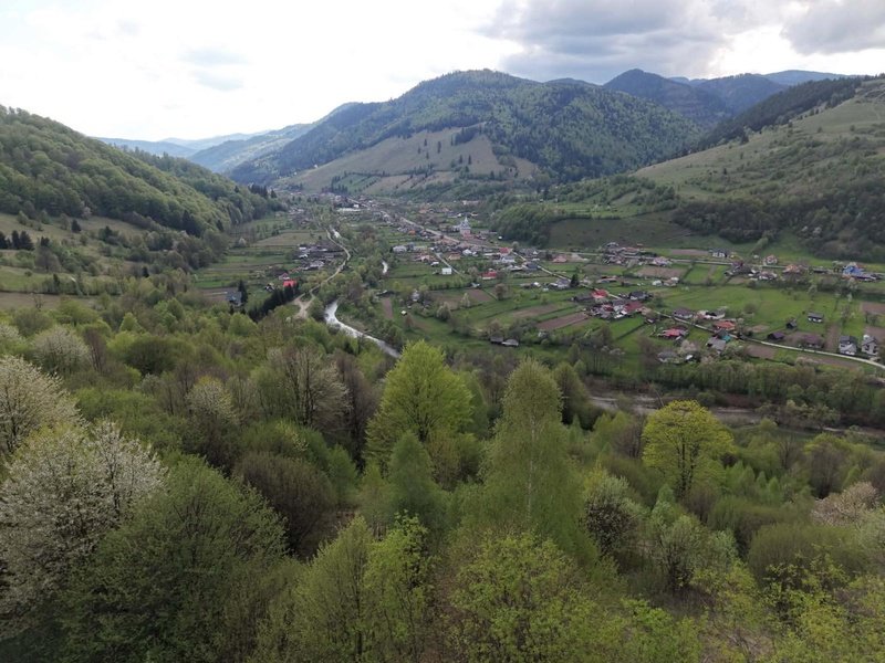 Neamț. O echipă de studenți din comuna Grințieș s-a calificat pentru titlul de „Sat European de Tineret 2027” 1 Vedere panoramică a satului din Neamț înconjurat de munți și păduri.