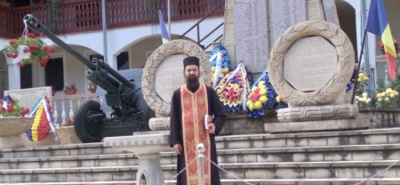 Fost polițist militar în fața monumentului Eroilor din Munții Neamțului.