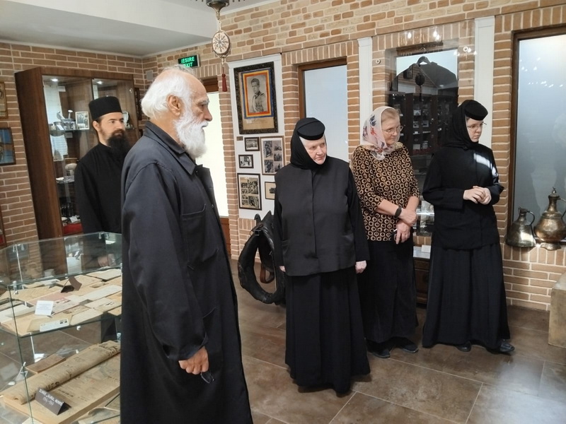 Grup de persoane în interiorul Mănăstirii Eroilor din Munții Neamțului.