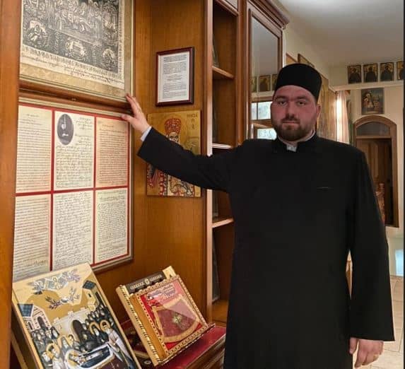 Doi arestați în cazul agresiunii asupra preotului din Vânători-Neamț Preot în Vânători-Neamț arătând documente religioase.
