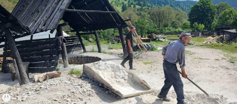 Persoane care lucrează la construcții în Valea Bicazului, pe teren rural.