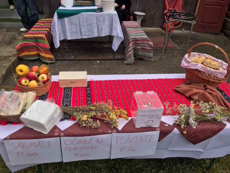 Mese cu produse traditionale si aranjamente florale la targ.