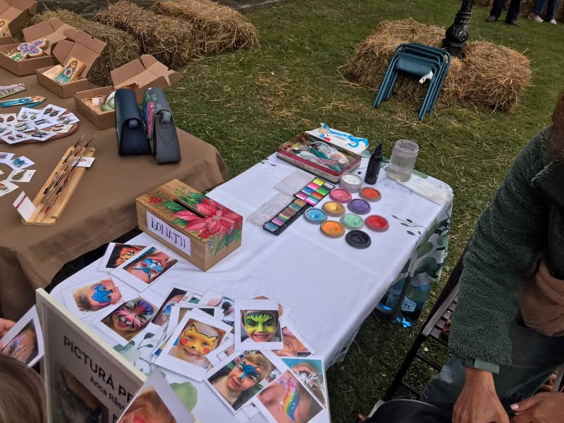 Tampoane colorate, picturi pe fata si accesorii la targ de artizanat in aer liber.