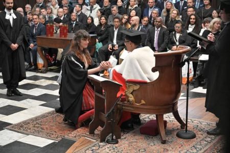 Cuplu de absolvenți în ceremonia de diplomație, schimb de jurăminte academice.