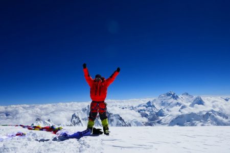 Alpinist în vârf de munte în Nepal, pe Trans-Himalaya, cu peisaj montan impresionant.