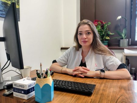 Alexandra Cumpănici – cel mai tânăr medic oncolog din Piatra-Neamț: „Am vrut toată viața să ajut” Tânărul medic oncolog Alexandra Cumpănici în birou, înconjurată de plante și echipamente medicale.