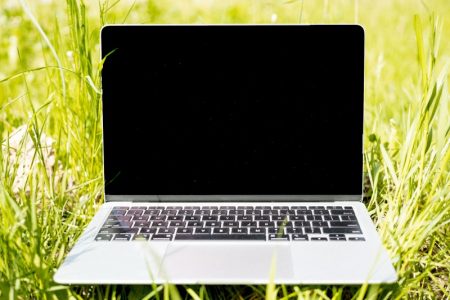A redefinit performanța: povestea neașteptată a lui Neo Laptop pe iarbă verde în aer liber, ecran negru.
