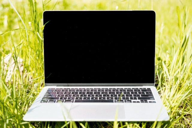 A redefinit performanța: povestea neașteptată a lui Neo Laptop pe iarbă verde în aer liber, ecran negru.