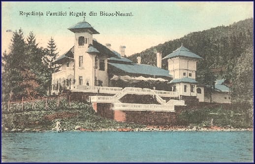 Construția rezidențială regală lângă lac, cu turnuri și trepte albe, înconjurată de pădure.